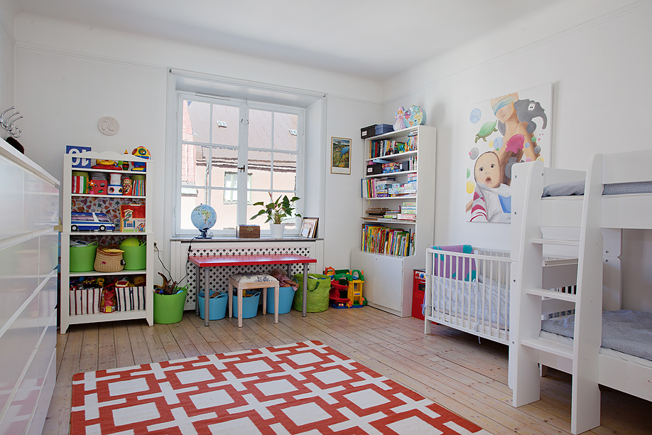 卧室与娱乐室何为一体的儿童房，色彩明艳，MINI版的书桌、书架也非常的小巧可爱。