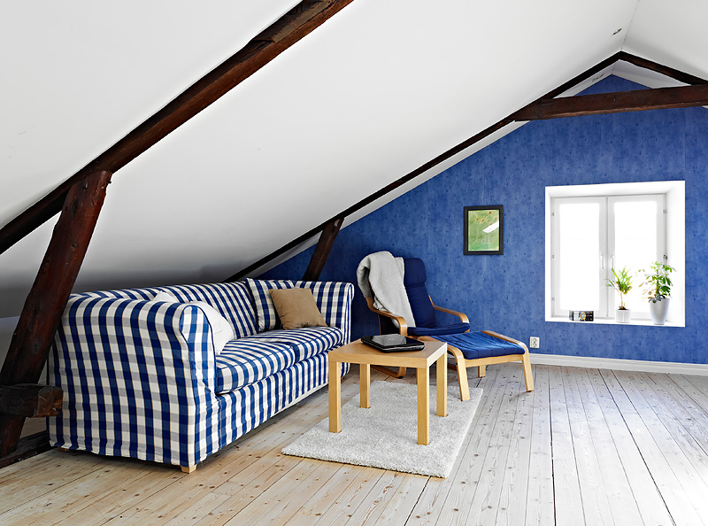 阁楼中独立的客厅，简洁又大方，海蓝色蓝白格子沙发与蓝白色的墙壁协调的充实了整个空间。