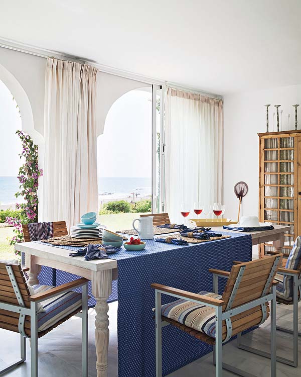 海蓝色的桌布让人很有好感，超大的落地窗引进充足的阳光。原木色的椅子和原木色的橱柜。整个空间都源自于大自然。