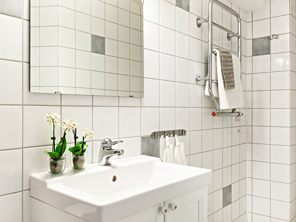 白色的洗手台上，放着几盆简易的盆栽，绿色洋溢。