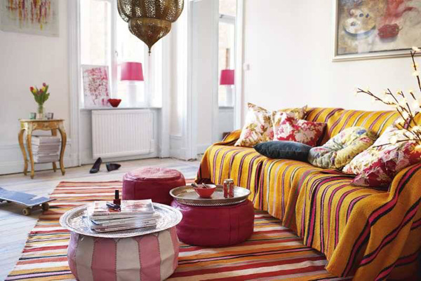 客厅是用摩洛哥地毯，放在地板和沙发上，颜色非常鲜艳，条形的图案。天花板上的灯饰是摩洛哥铜灯，非常有复古的味道。