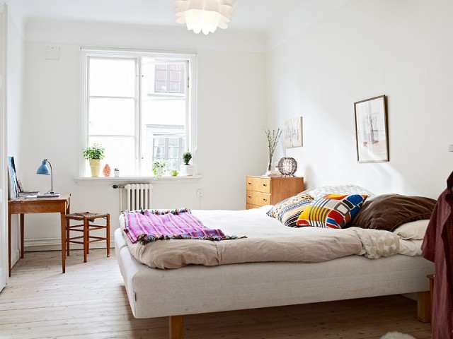 纯白色的卧室中摆放的是实木打造的书桌和5斗柜。