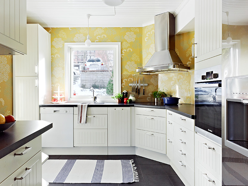 圆弧形的厨房以扬长避短的方式设计，而且还选用了亮丽的黄色壁纸，很亮堂。