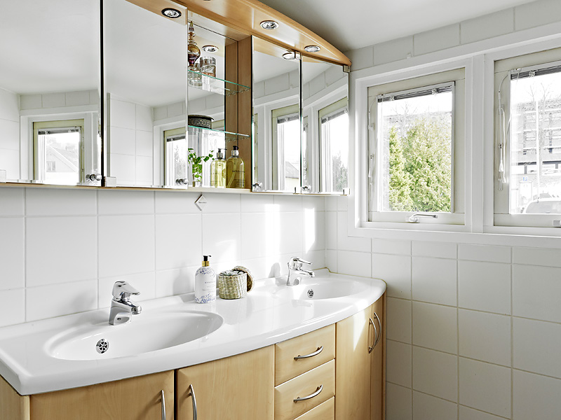 浴室采用原木色和白色的装修，洗手台上面的镜子，打开便是浴室柜哟。