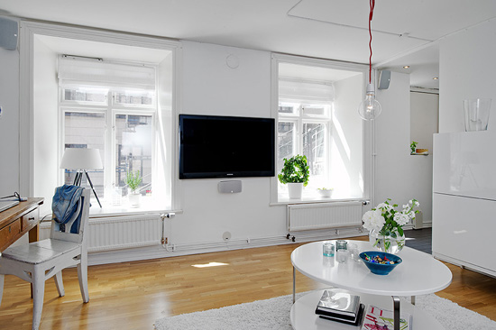 客厅里没有设计一个电视柜，而是将电视挂在两扇窗户中间的空白处，节省空间的同时又不失美观。