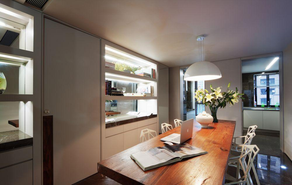 小公寓的餐厅是个十足的机能强大，橱柜和展示柜合二为一。长的木质餐桌有时也可以充当书桌使用。