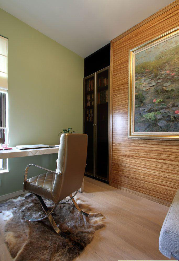 这是书房，简单的房间因为低调奢华木质墙面和金色边框的大幅装饰画而显得不平凡。