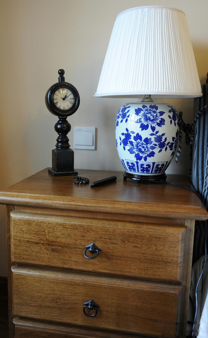 床头柜也是实木制造而成的，灯具是青花瓷的图案。