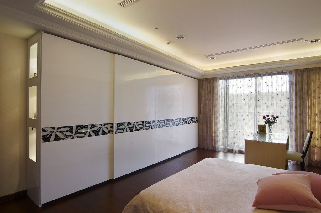 卧室墙面版以水平的金属线框搭配雾面的壁纸，再加上黑色反白的纹饰图腾，串联起空间的不同属性和个性。