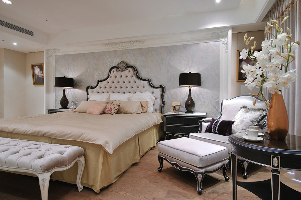 主卧室以金米色为主，床头白色艺术框衬托壁纸图纹的细腻质感。