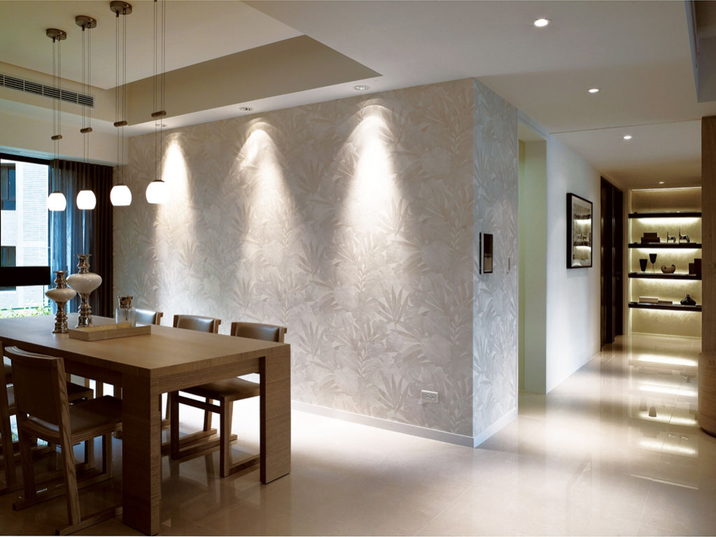 餐厅视觉焦点落在餐桌后的装饰墙，铺满具象枝叶图纹的白色壁纸墙，搭配着洗墙的灯光展现了质朴原味的美感。