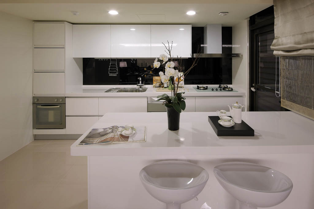 厨房区域以白色为主体，搭配上吧台的配置，营造出悠闲的生活景象。