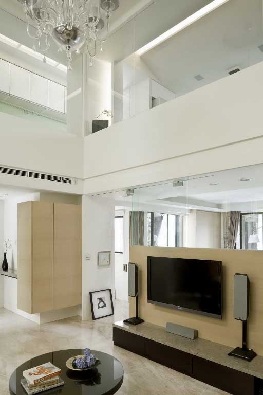 客厅保有挑高的气势，透过立面清玻璃的安排，强调通透及延伸的空间感受。