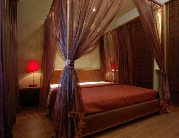 大大的卧室选择了各种层次的红色，床上的纱幔和壁纸让卧室显得温馨又有异域风情。