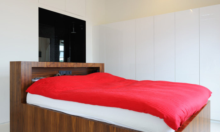 原木的床，搭配红色的床品，鲜艳又活泼。