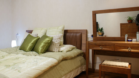 主卧，实木床和梳妆台，搭配绿色的床品，清新古典。
