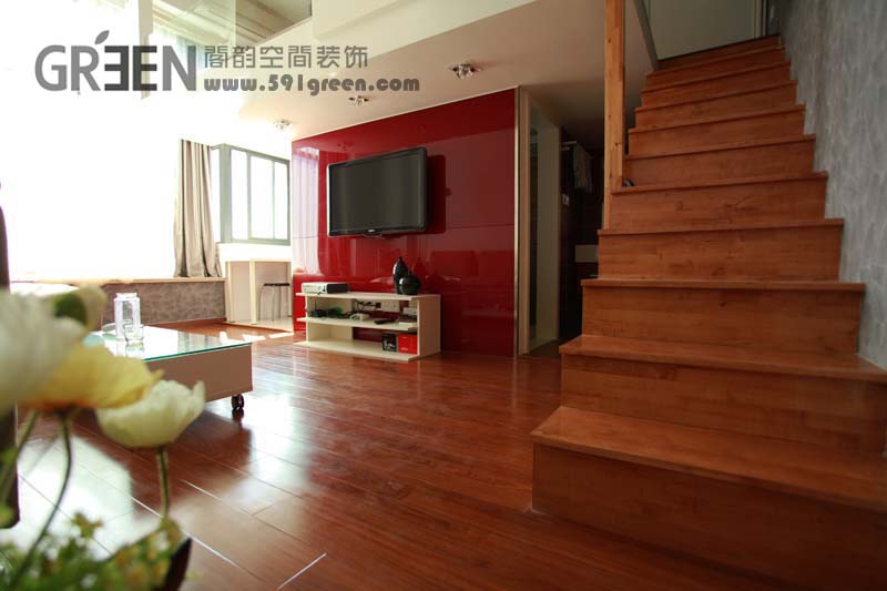 木质的地板，原木的呈现，搭上纯红色的电视背景墙，显得如此的前卫时尚。