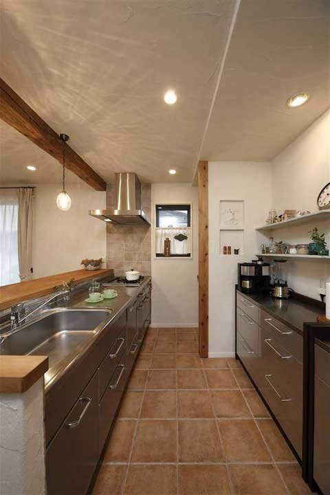 厨房的地面铺上赤陶花砖，很有旧房子的古朴气息。不锈钢的橱柜清洁卫生也很方便。一边是炉灶及洗水槽，另一边则是餐柜，分工明确。 