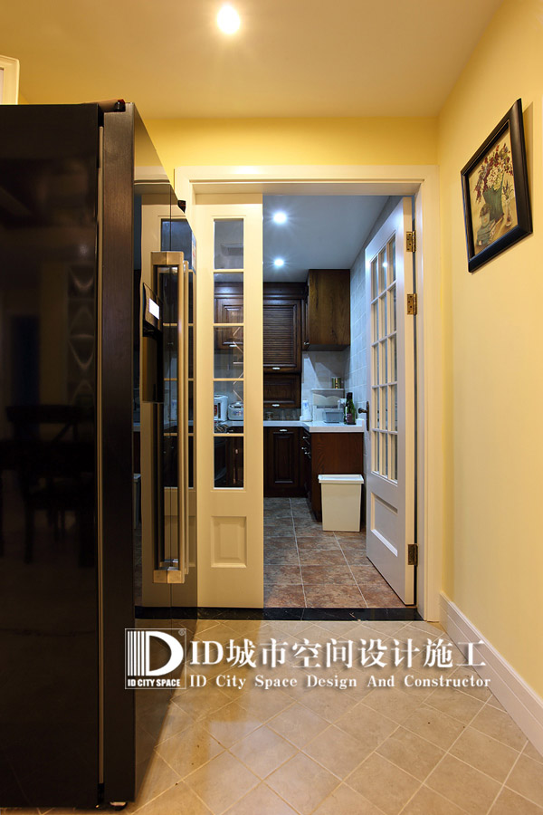 双开门的冰箱坐落于厨房的进门处让宽阔的过道也变为厨房的一部分。