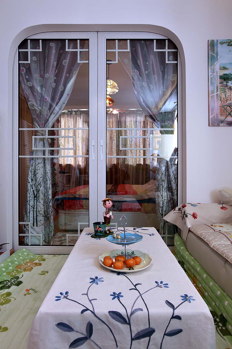 小巧的家，采用推门来阻隔客厅和卧室。中国式的花纹设计，纯白的玻璃推门让这个隔断变得又与众不同。
