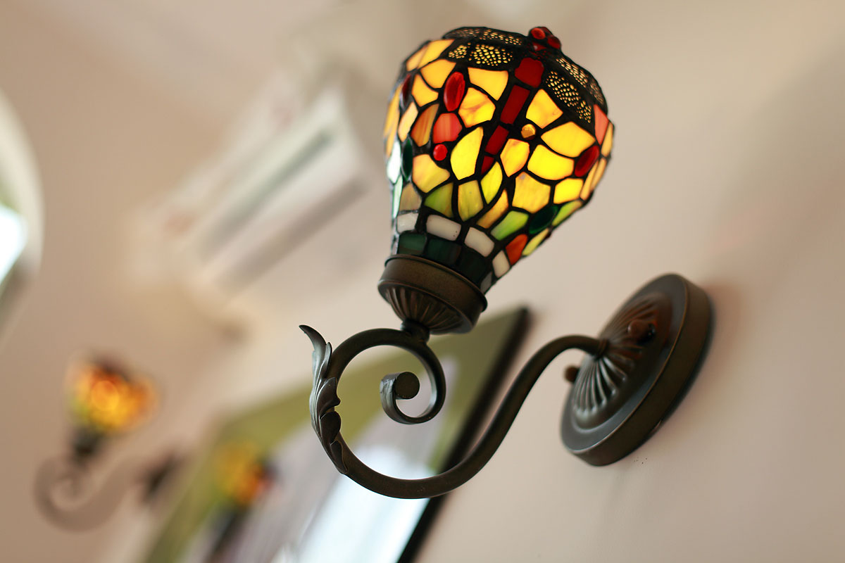 卧室中的琉璃灯和家中的灯具都采用了同一款式，大大的增加了空间的统一性。