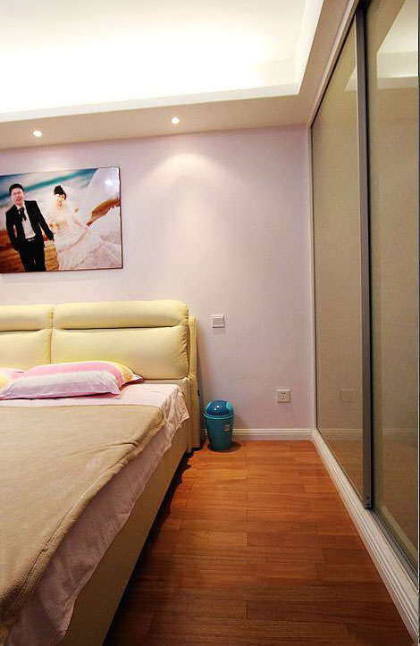 卧室的颜色很清新，嫩黄色的床板、粉红色的墙面、墨绿色的衣柜、棕色的地板。四种颜色将卧室妆点的清爽舒适。
