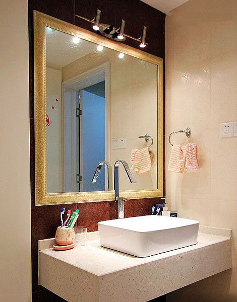 洗手台上方采用了长方形的镜面，设计了三盏灯具，镜面将灯光照映在卫生间的每一个角落。