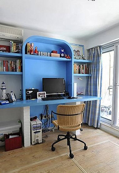 书房做了抬高设计，地板下方都是储物空间。蔚蓝色整体书架在阳光下显得格外清新宁静，书房的墙面完全采用白色涂料，让蓝白的配色更加鲜明