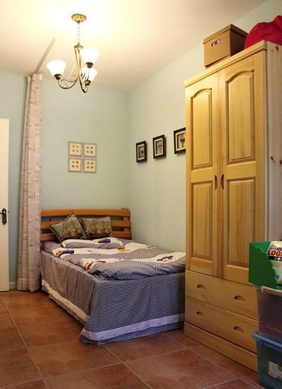 另一间卧室则是木制家居搭配冷色调，一个木制衣柜尽显对简约的追求。床边的窗帘设计，让主人们的空间更加独立。

