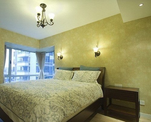 卧室的吊灯和壁灯跟客厅的同款，遥相呼应，隐隐的花朵纹理使米灰色的床品显得秀丽典雅。