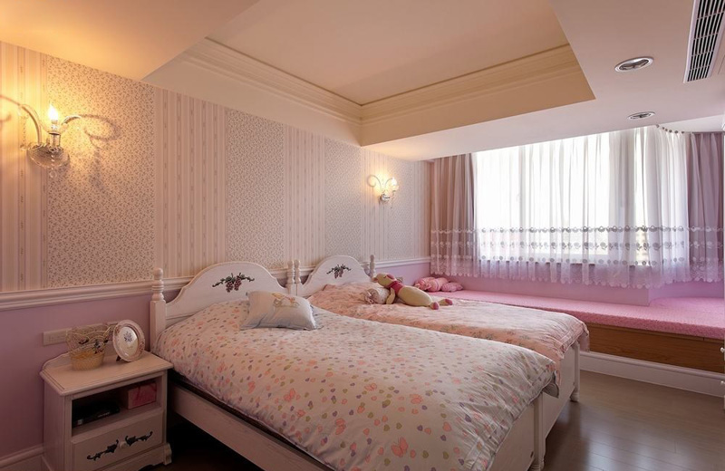 以粉红与碎花为基调，两个并排的美式风格单人床与三个衣柜铺排出属于两个小女孩的秘密基地，临窗的卧榻区更是设计师贴心设计的亲子空间。