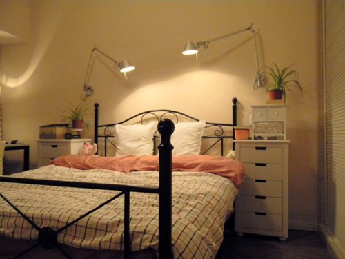 折角台灯和简单的铁架双人床让卧室显得很温馨!