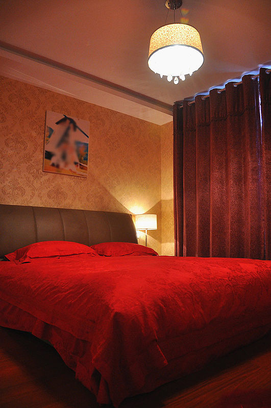 卧室里的设计也是以温馨调为主，酒红色的窗帘和大红色的床品十分温馨，空气里弥漫着浪漫的调调。