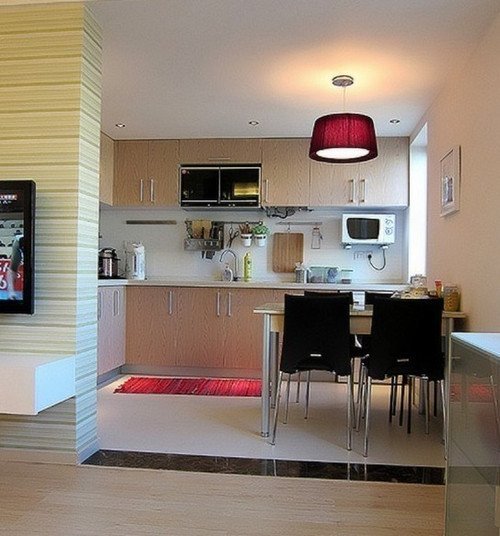 开放式的厨房与饭厅二合一，紫红色的灯罩与地毯相呼应，淡色的厨柜与黑色的餐椅却强烈的对比，搭配出来的效果却出奇的好。
