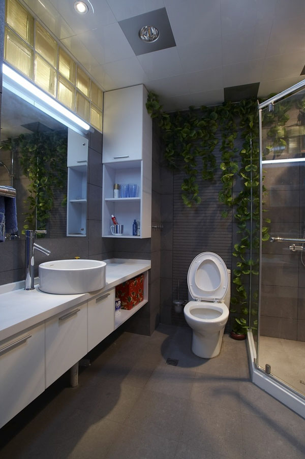 卫生间里的各种洗浴用品都采用了简洁的白色，绿色植物点缀了卫生间。