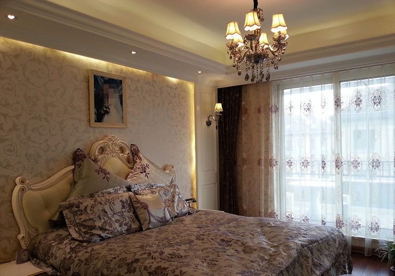 卧室也充满了欧式的元素，吊灯，床头靠背，背景墙纸等。