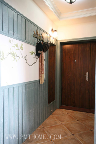进门，门厅地面采用仿古砖铺贴，与木质背景墙相映成趣。
