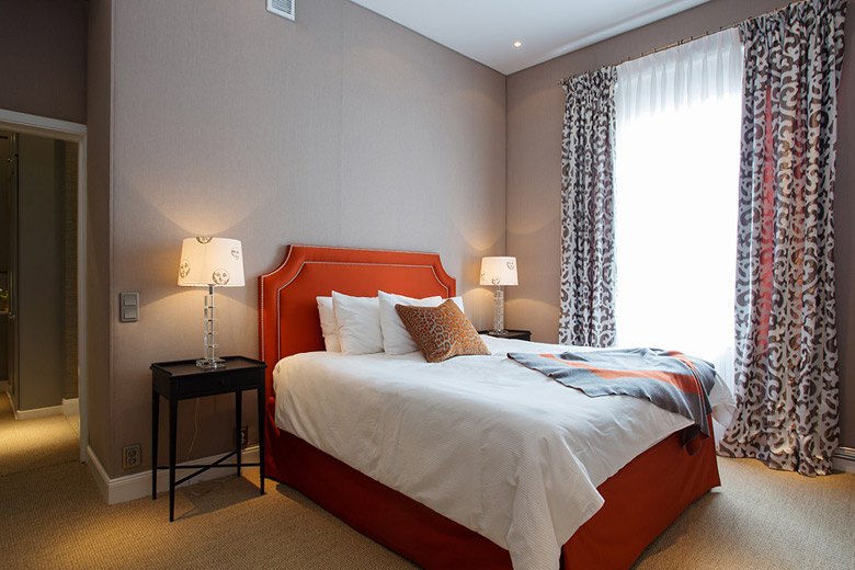 浅色的背景墙搭配橘红色的床，温暖简约。