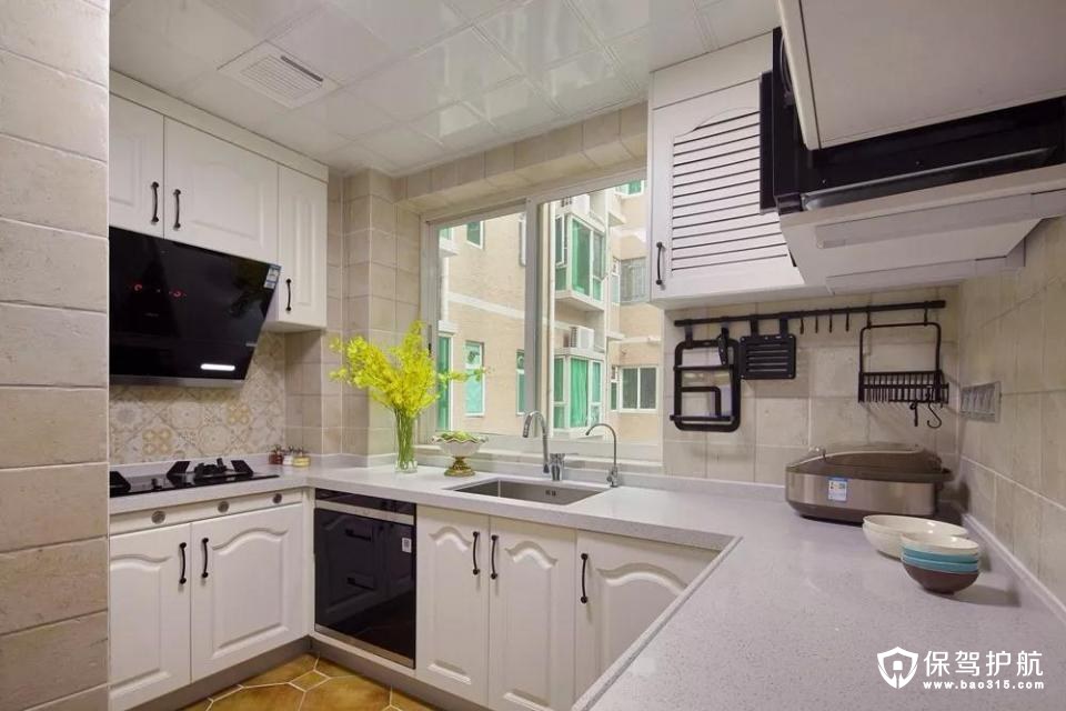 设计师在厨房里大胆运用黑白两色，摆上一些黄色的干花，既活泼了空间，又让厨房和客厅在色调上有了明显区别。