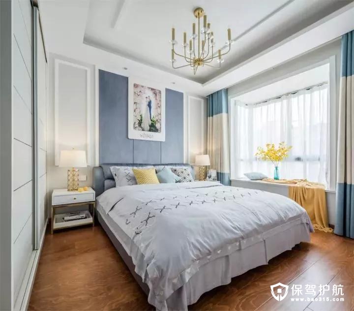 主卧的床头是边框造型，中间大面积的灰蓝色，再挂一幅婚纱照，结合现代舒适的淡蓝色床单，