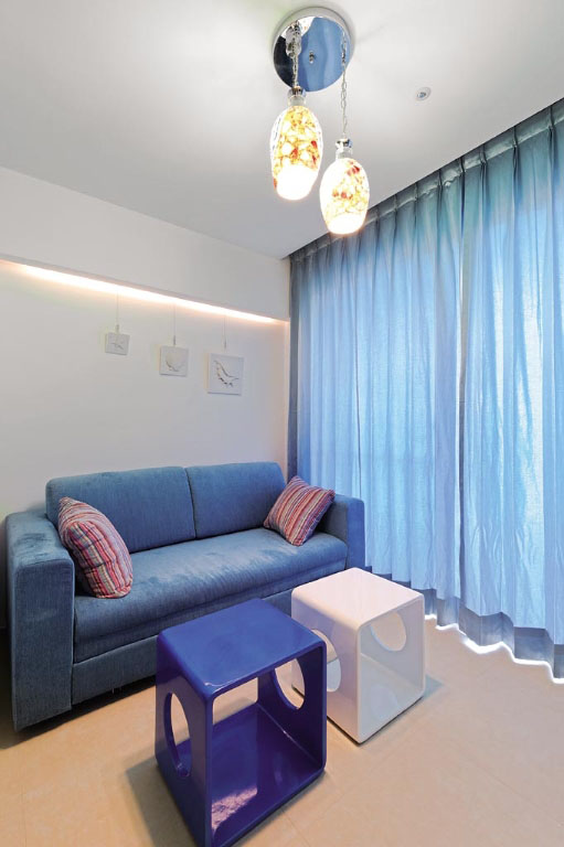 蓝色布质沙发床与窗帘的彩度同款,吊灯以手作质感为主,静缓的延伸出